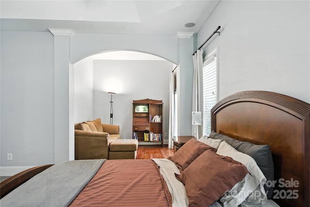 4605 Sarandon Ct, Charlotte, NC 28215 - bedroom featuring arched walkways, wood finished floors, and a skylight