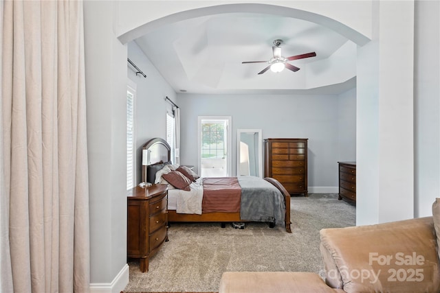 4605 Sarandon Ct, Charlotte, NC 28215 - carpeted bedroom with a tray ceiling, arched walkways, and ceiling fan
