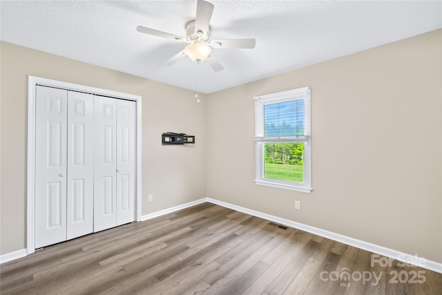 13715 Mayes Rd, Huntersville, NC 28078 - unfurnished bedroom featuring wood finished floors, a closet, a ceiling fan, and a textured ceiling