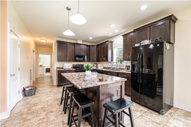 3659 Vashti Rd, Taylorsville, NC 28681 - kitchen featuring black appliances, dark brown cabinetry, a kitchen bar, hanging light fixtures, and light stone counters