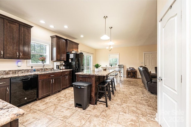 3659 Vashti Rd, Taylorsville, NC 28681 - kitchen featuring black appliances, a kitchen breakfast bar, dark brown cabinets, light stone counters, and a kitchen island