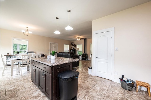 3659 Vashti Rd, Taylorsville, NC 28681 - kitchen featuring decorative light fixtures, dark brown cabinetry, a ceiling fan, a chandelier, and light stone countertops