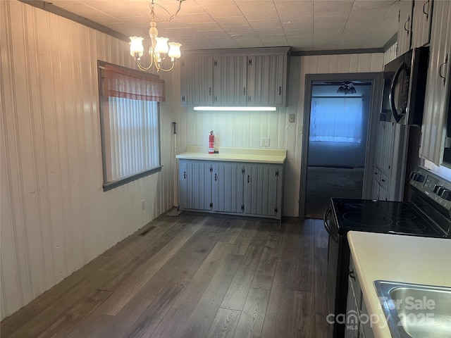 9314 Seymour Ln, Davidson, NC 28036 - kitchen with black appliances, dark wood-style flooring, a chandelier, wooden walls, and ornamental molding