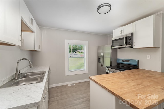 210 Marshall St, Rock Hill, SC 29730 - kitchen with stainless steel appliances, light wood-type flooring, white cabinetry, ornamental molding, and a peninsula