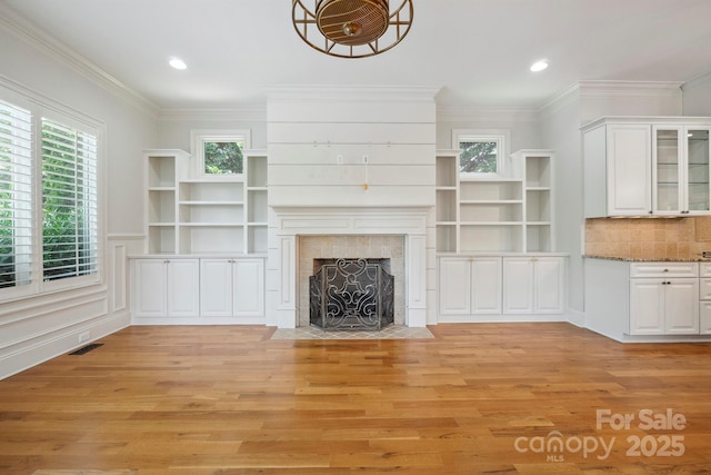 20635 Queensdale Dr, Cornelius, NC 28031 - unfurnished living room with light wood-style flooring, a fireplace, ornamental molding, and recessed lighting
