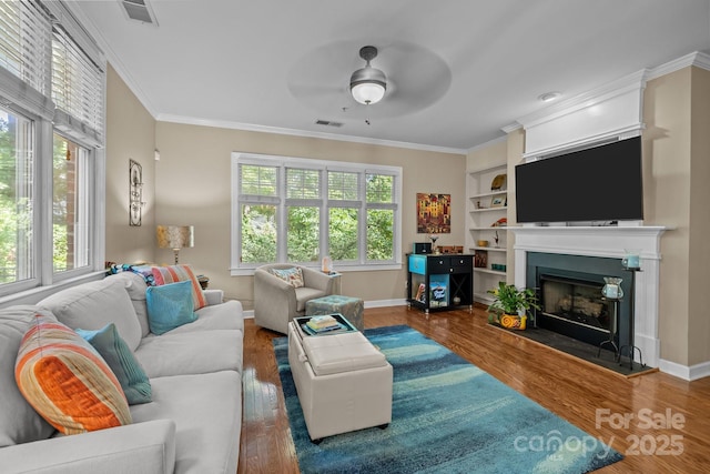 4854 S Hill View Dr, Charlotte, NC 28210 - living area featuring a ceiling fan, wood finished floors, healthy amount of natural light, and crown molding