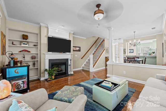 4854 S Hill View Dr, Charlotte, NC 28210 - living area with wood finished floors, a fireplace with flush hearth, ornamental molding, stairs, and built in features