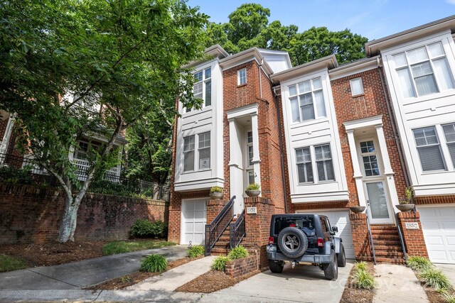 4854 S Hill View Dr, Charlotte, NC 28210 - view of property featuring an attached garage, brick siding, and driveway