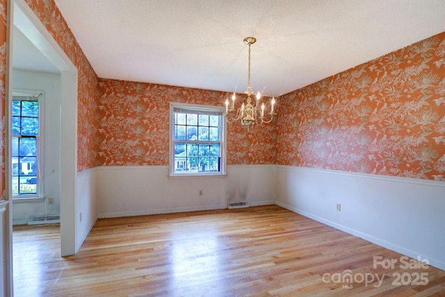 1658 Buckingham Ave, Gastonia, NC 28054 - spare room featuring a chandelier, light wood-style floors, wallpapered walls, and wainscoting
