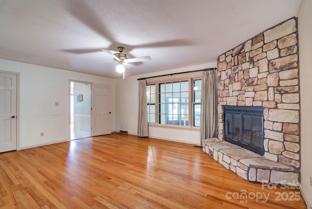 1658 Buckingham Ave, Gastonia, NC 28054 - unfurnished living room with wood finished floors, ceiling fan, and a stone fireplace