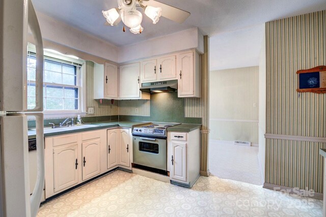 1658 Buckingham Ave, Gastonia, NC 28054 - kitchen featuring stainless steel electric range, under cabinet range hood, a ceiling fan, wallpapered walls, and light floors