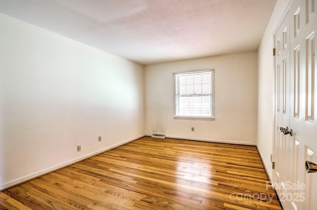 1658 Buckingham Ave, Gastonia, NC 28054 - unfurnished bedroom with wood finished floors, a closet, and a textured ceiling