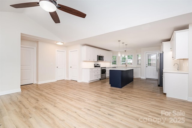 43 Paddington Dr SW, Concord, NC 28025 - kitchen featuring appliances with stainless steel finishes, a kitchen island, light wood-style floors, and lofted ceiling