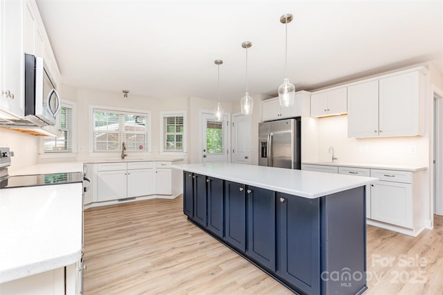 43 Paddington Dr SW, Concord, NC 28025 - kitchen featuring stainless steel appliances, light wood-style floors, light countertops, and white cabinets