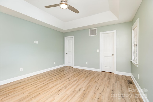 43 Paddington Dr SW, Concord, NC 28025 - unfurnished bedroom featuring wood finished floors, a raised ceiling, and a ceiling fan