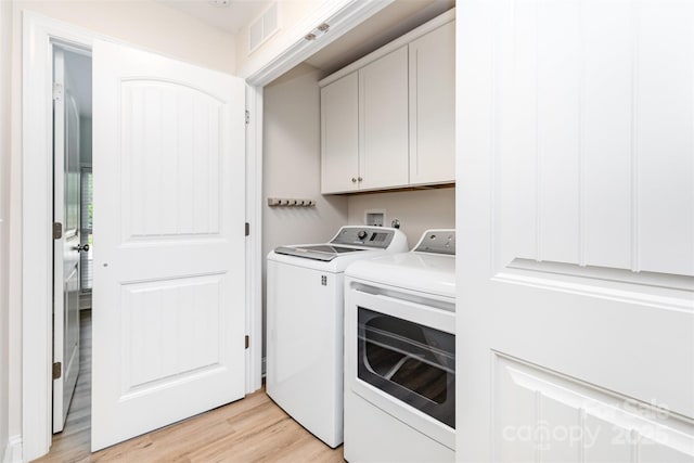 43 Paddington Dr SW, Concord, NC 28025 - washroom featuring cabinet space, washer and dryer, and light wood-style flooring