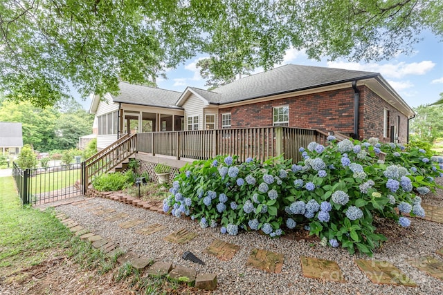 43 Paddington Dr SW, Concord, NC 28025 - rear view of house with a sunroom, brick siding, a deck, and roof with shingles