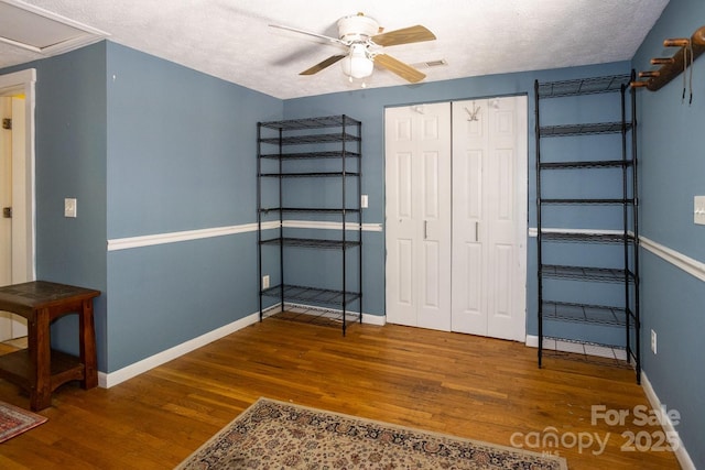 3153 US-70 Hwy E, Black Mountain, NC 28711 - unfurnished bedroom with wood finished floors, a closet, a ceiling fan, and a textured ceiling