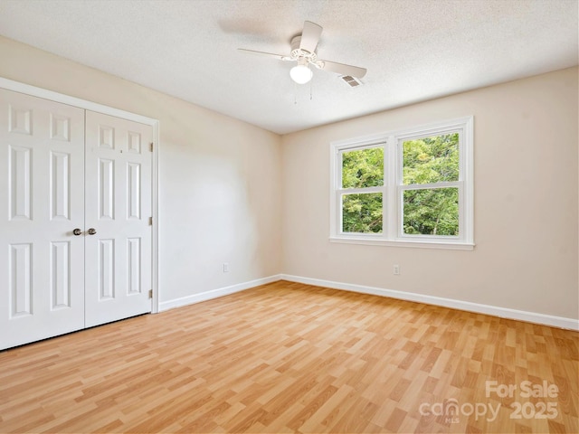 5632 Zion Church Rd, Concord, NC 28025 - unfurnished bedroom featuring light wood-style flooring, a closet, ceiling fan, and a textured ceiling
