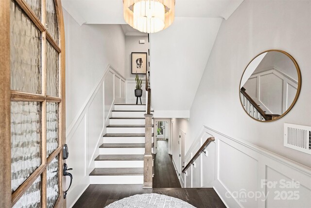 622 Mattie Rose Ln, Charlotte, NC 28204 - staircase featuring a towering ceiling, wood finished floors, wainscoting, and a decorative wall