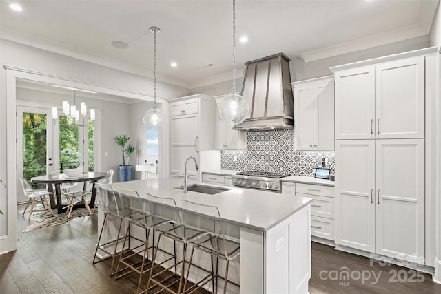 622 Mattie Rose Ln, Charlotte, NC 28204 - kitchen featuring dark wood finished floors, a kitchen island with sink, stove, light countertops, and ornamental molding