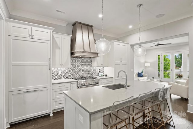 622 Mattie Rose Ln, Charlotte, NC 28204 - kitchen with custom exhaust hood, open floor plan, stainless steel stove, white cabinets, and crown molding