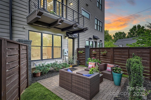 622 Mattie Rose Ln, Charlotte, NC 28204 - patio terrace at dusk featuring a balcony, an outdoor hangout area, a fenced backyard, and a patio area