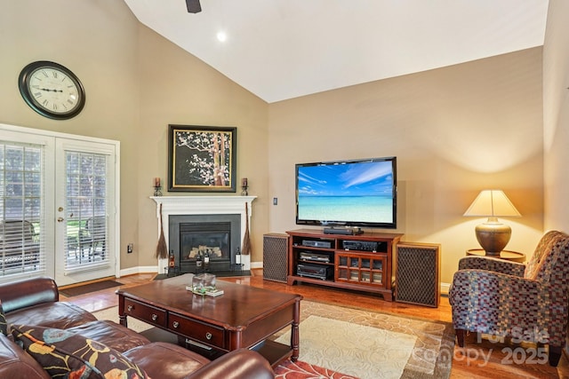 7612 Maple Bluff Ln, Concord, NC 28025 - living room with high vaulted ceiling, a glass covered fireplace, wood finished floors, and french doors