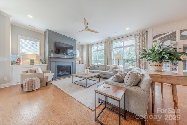 5256 Meadowcroft Way, Fort Mill, SC 29708 - living room featuring wood finished floors, a glass covered fireplace, ornamental molding, ceiling fan, and recessed lighting