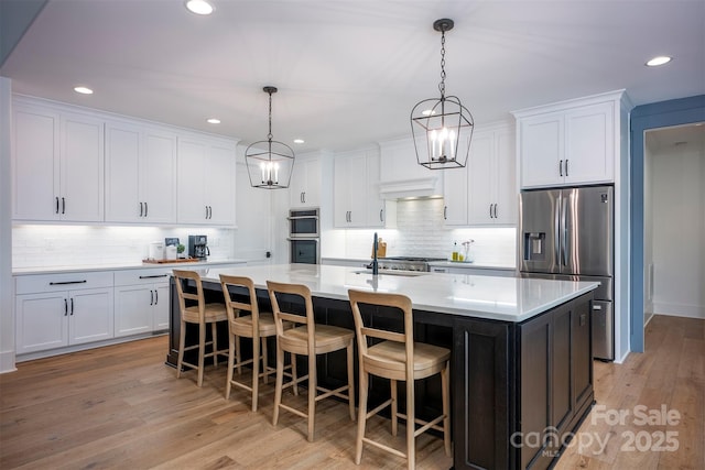 176 Windwood Ln, Troutman, NC 28166 - kitchen with appliances with stainless steel finishes, tasteful backsplash, white cabinetry, a spacious island, and recessed lighting