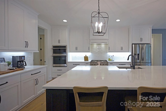 176 Windwood Ln, Troutman, NC 28166 - kitchen with appliances with stainless steel finishes, decorative backsplash, white cabinetry, hanging light fixtures, and recessed lighting