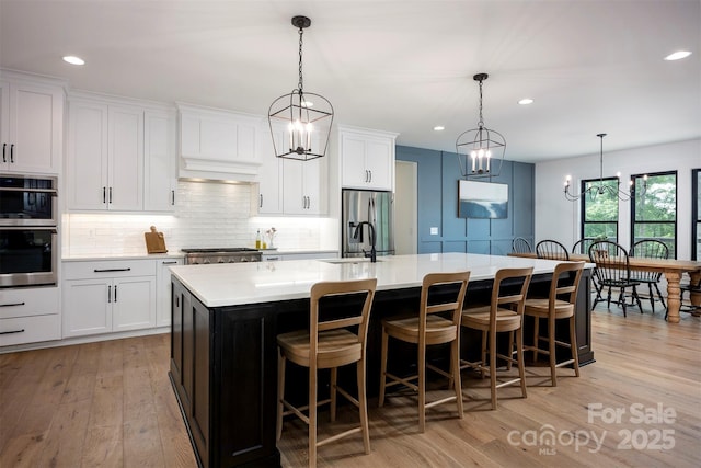 176 Windwood Ln, Troutman, NC 28166 - kitchen with a spacious island, decorative backsplash, recessed lighting, light wood-style flooring, and stainless steel appliances