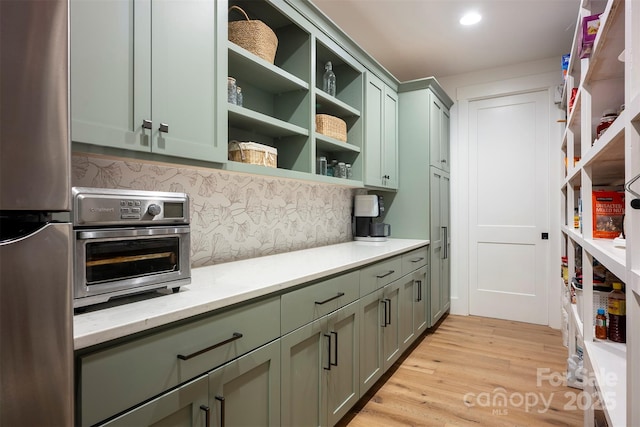 176 Windwood Ln, Troutman, NC 28166 - kitchen with freestanding refrigerator, green cabinetry, open shelves, decorative backsplash, and recessed lighting