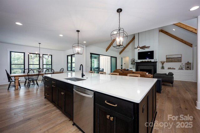 176 Windwood Ln, Troutman, NC 28166 - kitchen featuring stainless steel dishwasher, dark cabinets, recessed lighting, a chandelier, and a fireplace