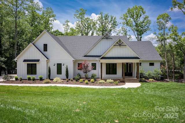 176 Windwood Ln, Troutman, NC 28166 - modern farmhouse with board and batten siding, roof with shingles, a front lawn, and covered porch