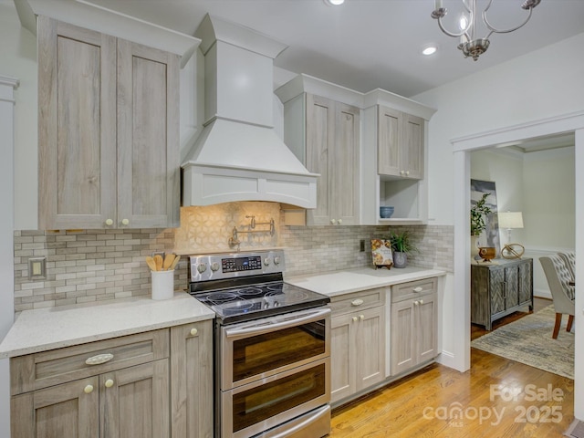 8508 Sandowne Ln, Huntersville, NC 28078 - kitchen with double oven range, premium range hood, light wood finished floors, decorative backsplash, and light stone countertops