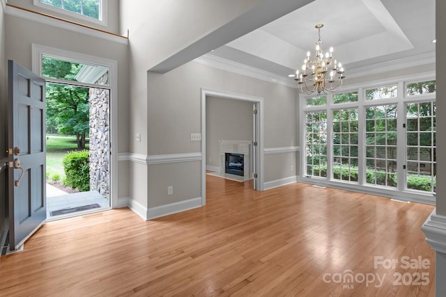 165 Futrell Lndg, New London, NC 28127 - entrance foyer featuring a tray ceiling, a chandelier, a fireplace with flush hearth, light wood-style flooring, and ornamental molding