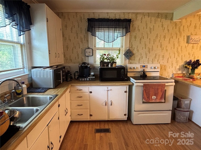 4059 10th Avenue Dr SW, Hickory, NC 28602 - kitchen featuring white range with electric stovetop, black microwave, light wood finished floors, crown molding, and wallpapered walls