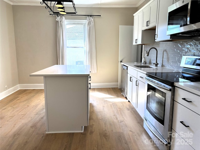 339 Mayflower Ave, Cramerton, NC 28032 - kitchen featuring stainless steel appliances, ornamental molding, a kitchen island, decorative backsplash, and light wood-style flooring