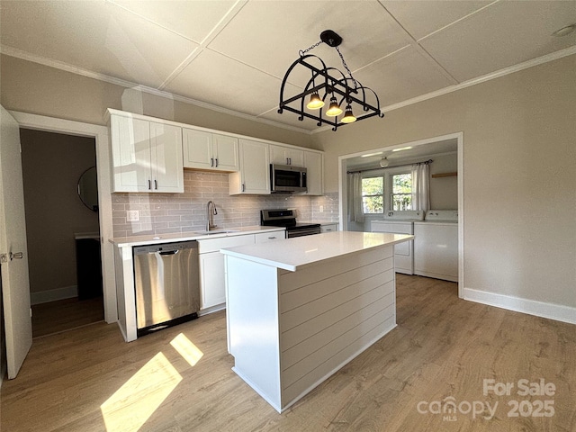 339 Mayflower Ave, Cramerton, NC 28032 - kitchen featuring stainless steel appliances, white cabinets, light countertops, ornamental molding, and light wood-style flooring