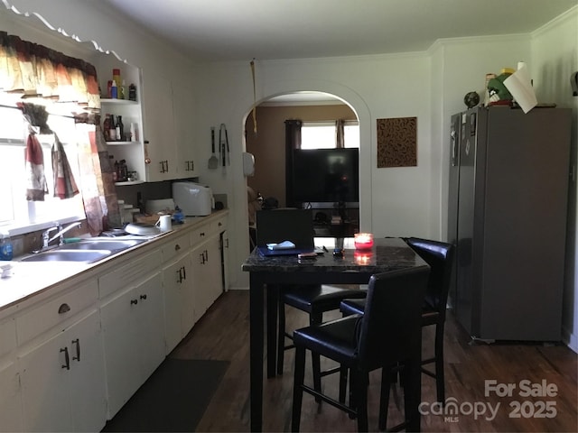 448 Belk St, Lancaster, SC 29720 - kitchen featuring freestanding refrigerator, arched walkways, dark wood-type flooring, and white cabinets
