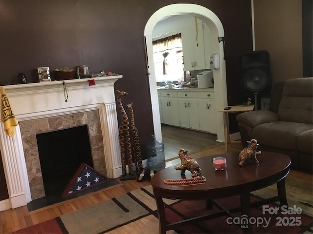 448 Belk St, Lancaster, SC 29720 - living area with wood finished floors, a tile fireplace, and arched walkways