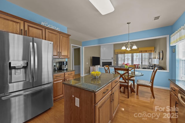 5238 Prosperity View Dr, Charlotte, NC 28269 - kitchen with appliances with stainless steel finishes, brown cabinets, light wood finished floors, open floor plan, and a center island