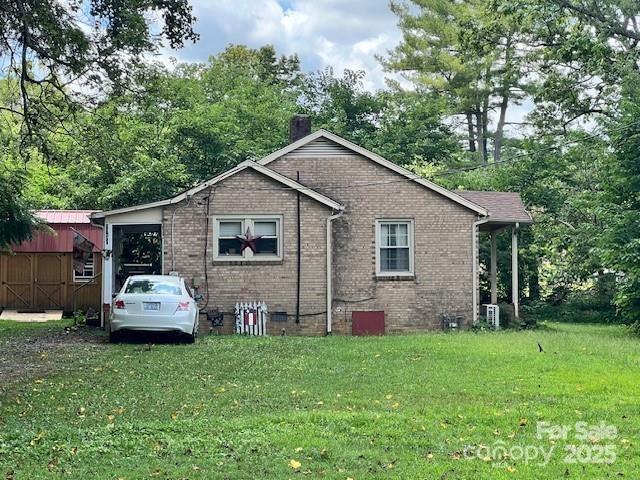 1545 Fairway Acres Dr, Lenoir, NC 28645 - view of property exterior with a lawn, brick siding, a chimney, crawl space, and an outbuilding