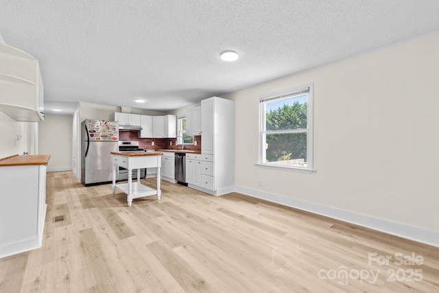 306 2nd Avenue Pl NE, Conover, NC 28613 - kitchen featuring stainless steel appliances, wooden counters, light wood-style flooring, white cabinetry, and a textured ceiling