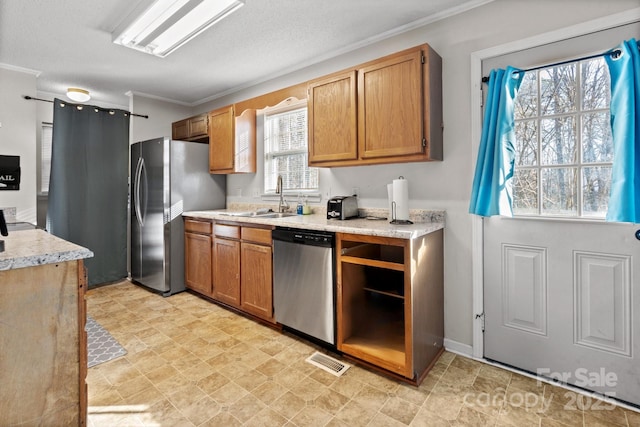 1013 Ashwood Pl, Salisbury, NC 28146 - kitchen with stainless steel appliances, ornamental molding, and brown cabinetry