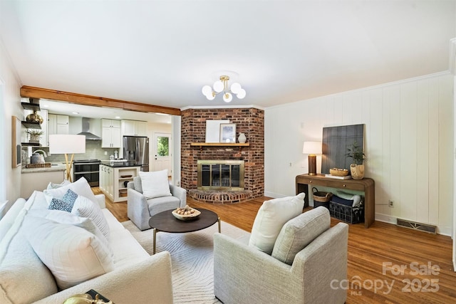 6150 Rocky Falls Rd, Charlotte, NC 28211 - living room with light wood finished floors, a fireplace, and ornamental molding