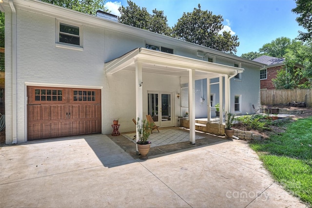 6150 Rocky Falls Rd, Charlotte, NC 28211 - view of front of house featuring an attached garage, french doors, a chimney, driveway, and brick siding