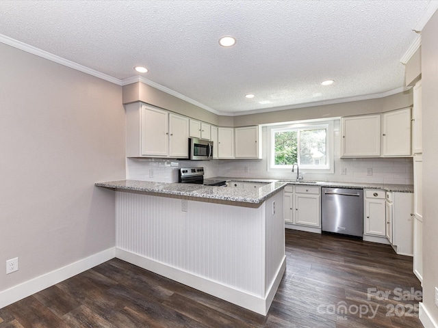 1117 Hidden Brook Ln, Clover, SC 29710 - kitchen with appliances with stainless steel finishes, a peninsula, a textured ceiling, tasteful backsplash, and dark wood-type flooring