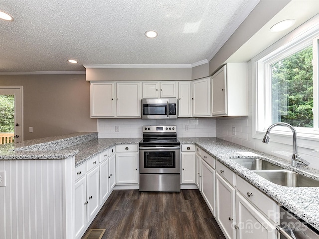 1117 Hidden Brook Ln, Clover, SC 29710 - kitchen with stainless steel appliances, a textured ceiling, white cabinetry, a peninsula, and dark wood-style floors
